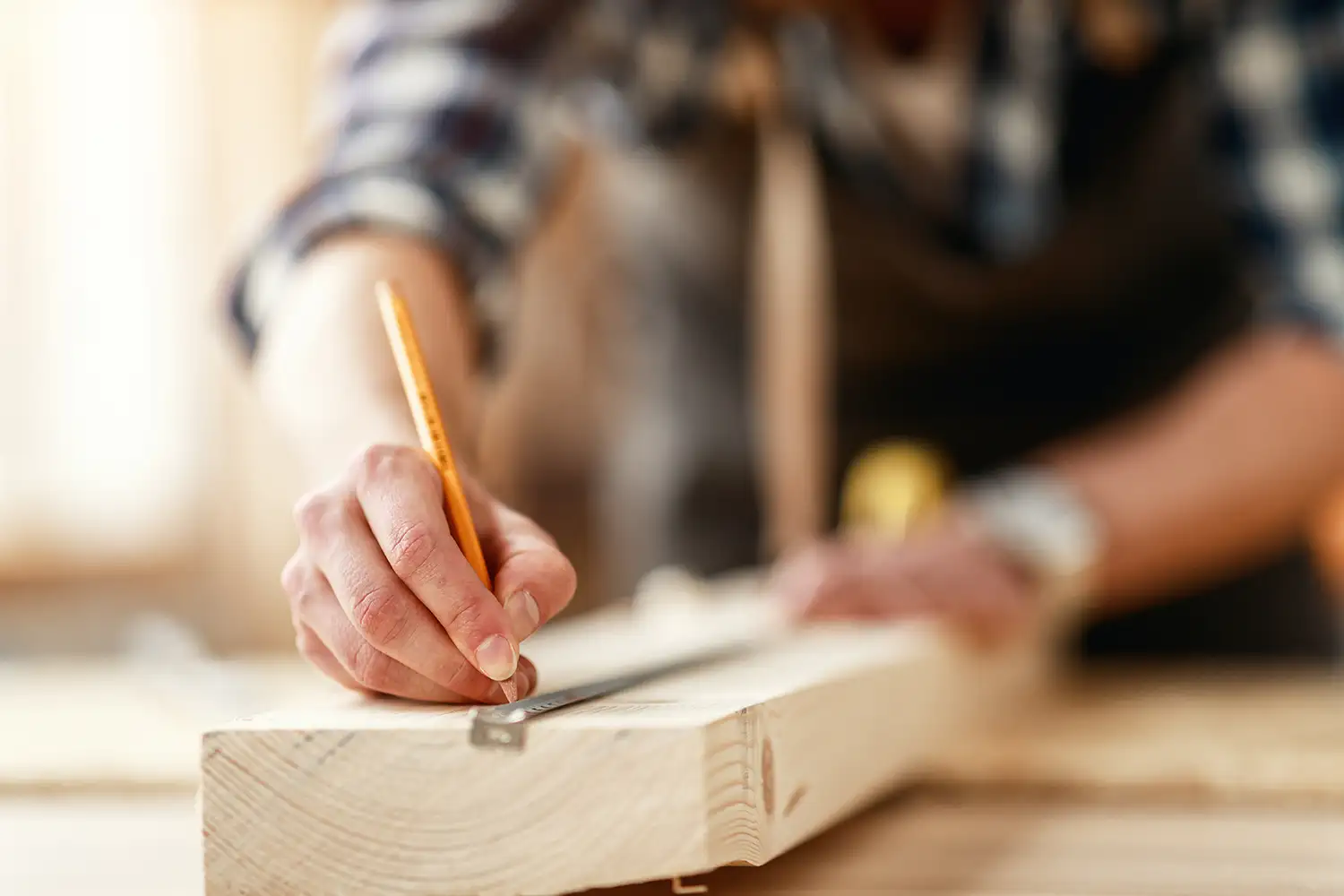 Craftsman measuring and marking a board