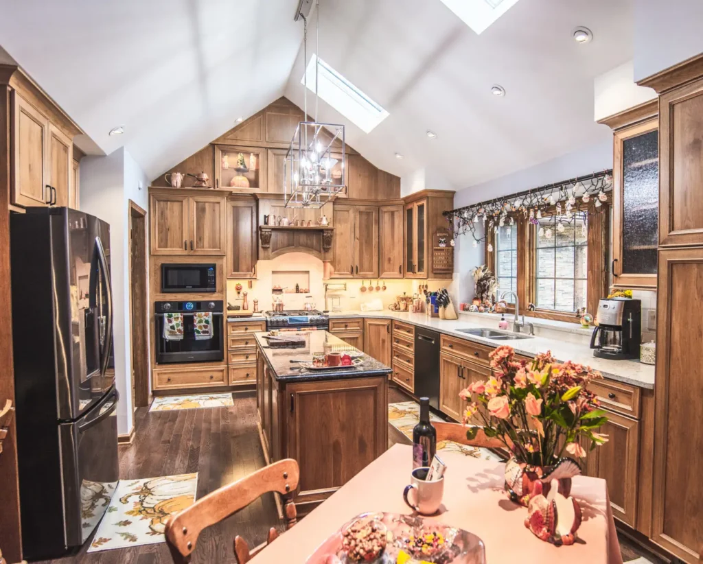 An open layout kitchen with a vaulted ceiling and beautifully built and stained custom cabinets