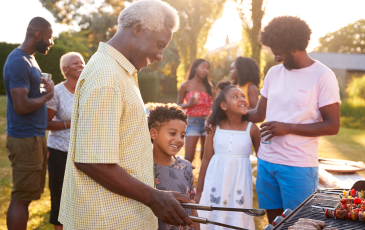 A multi-generational family enjoying themselves at a backyard BBQ