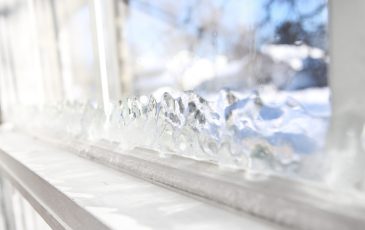 Ice forming on the inside glass of a drafty window in winter Ice forming on the inside glass of a drafty window in winter