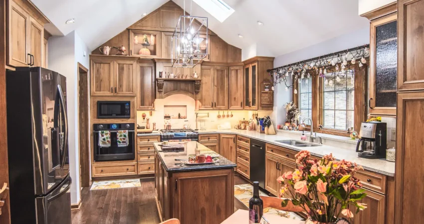 An open layout kitchen with a vaulted ceiling and beautifully built and stained custom cabinets