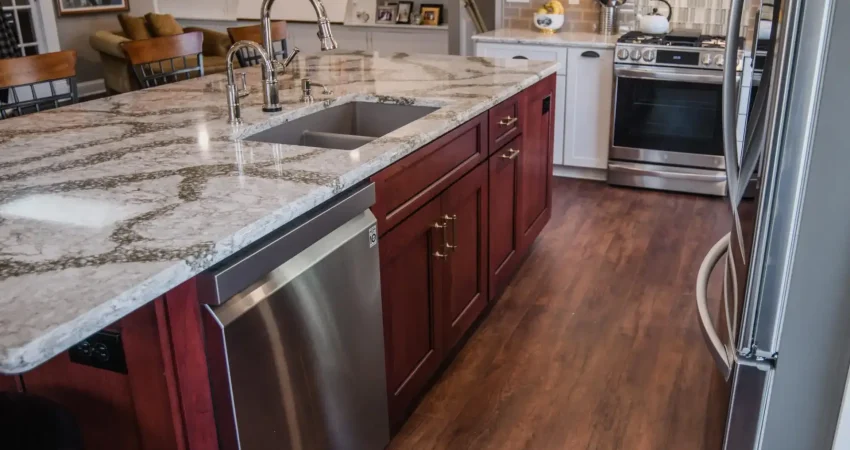 Kaz Home Improvements kitchen remodel in Amherst Western New York featuring a quartz island countertop, stainless steel sink, and dark cherry cabinetry