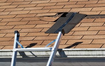 Fixing damaged roof shingles. A section was blown off after a storm with high winds causing a potential leak.