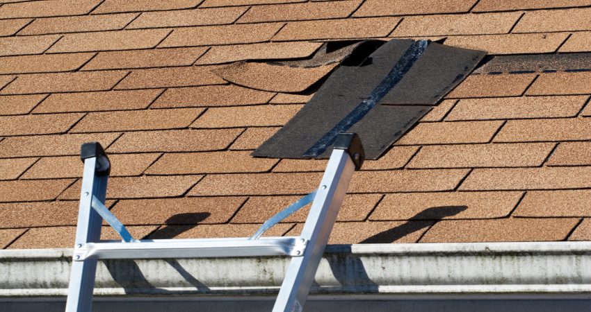 Fixing damaged roof shingles. A section was blown off after a storm with high winds causing a potential leak.