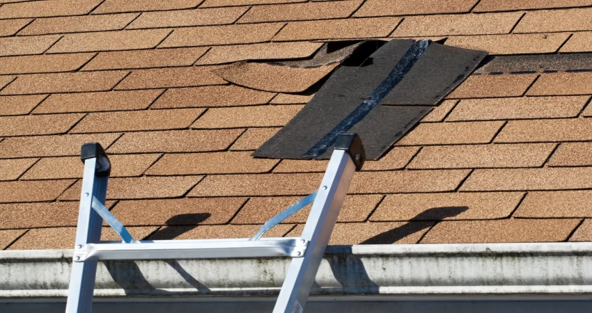 Fixing damaged roof shingles. A section was blown off after a storm with high winds causing a potential leak.