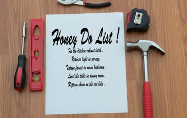 A to-do list on a table with varius tools–including a hammer, scre driver, tape measure and pliers