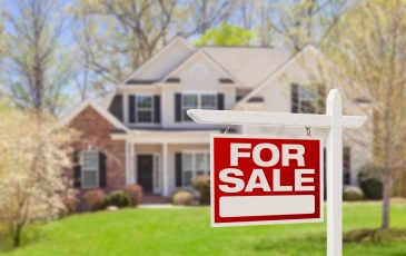 Home For Sale Real Estate Sign and Beautiful New House.