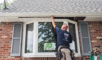 A Kaz exterior craftsman installing vinyl siding and windows at a home