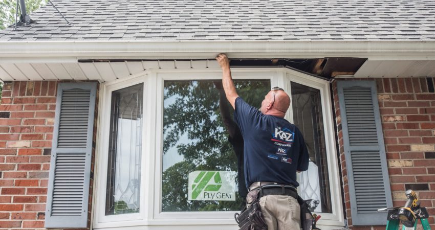 A Kaz exterior craftsman installing vinyl siding and windows at a home